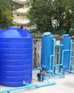 Blue water storage tank beside filtration columns