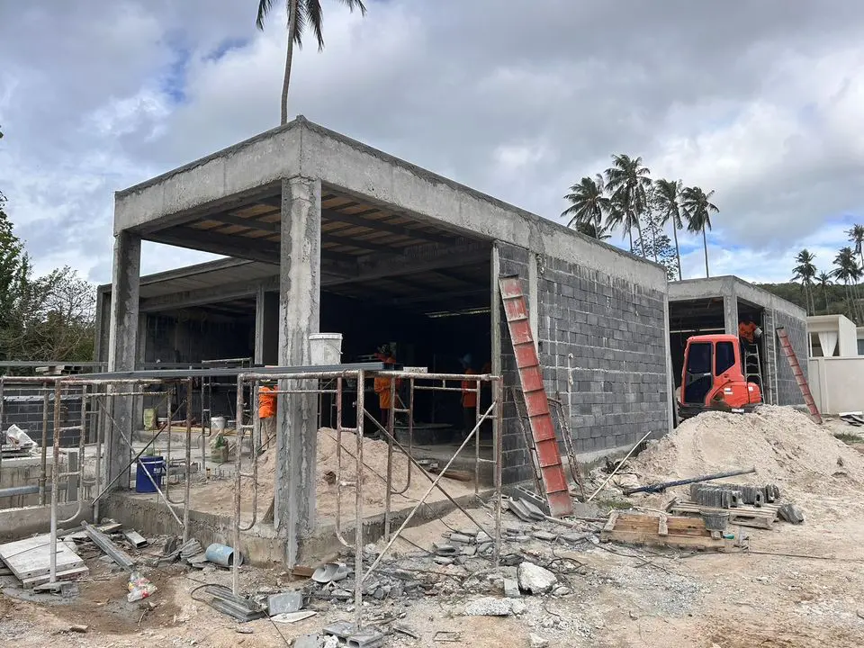 Concrete villa frame with block walls and an excavator on site