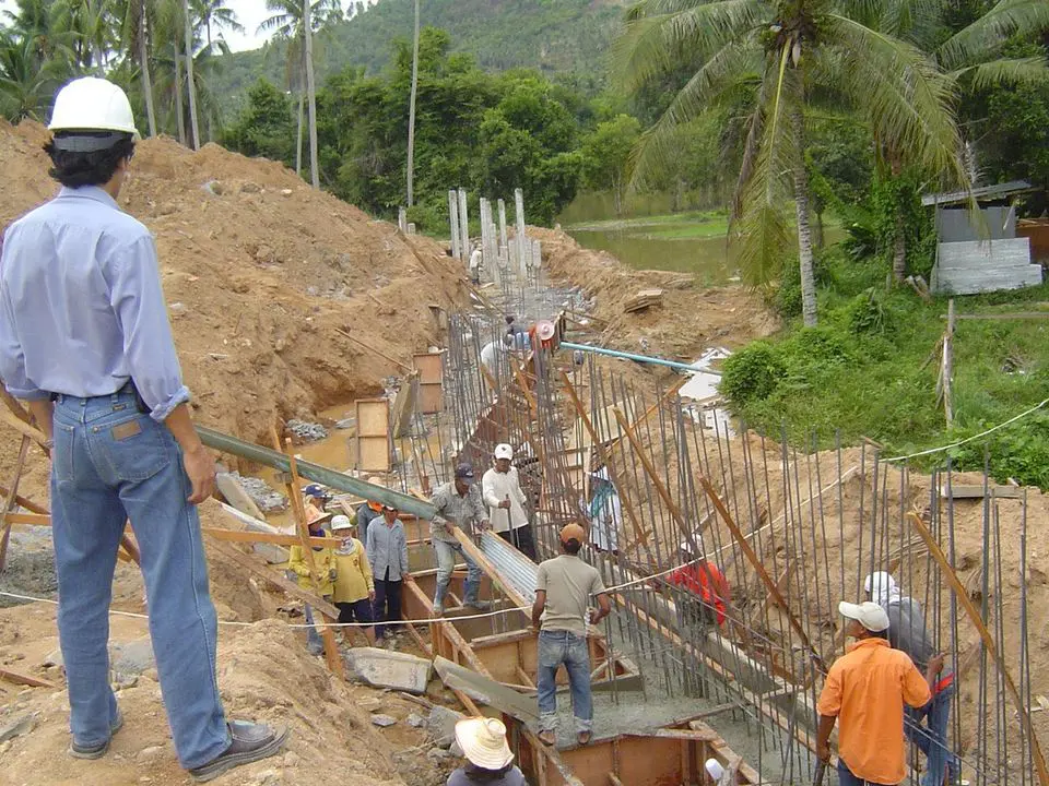 Site engineer in a hard hat overseeing retaining-wall work