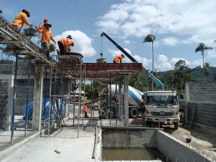 Site crew placing a suspended slab, with the company's own concrete mixer truck